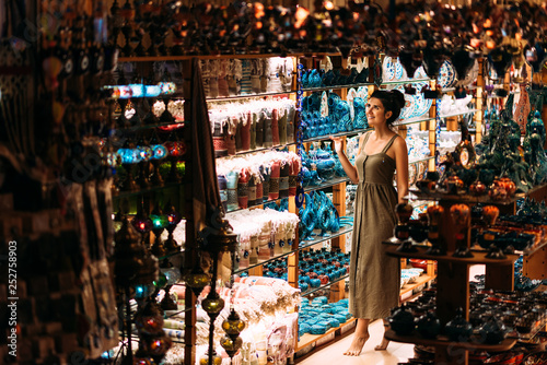 Beautiful girl in a souvenir shop in Turkey. Girl chooses a souvenir Oriental shop. Street shop. Turkish Souvenirs. Oriental bazaar. Turkish Bazaar. Tourist shop. Moroccan Bazaar.
