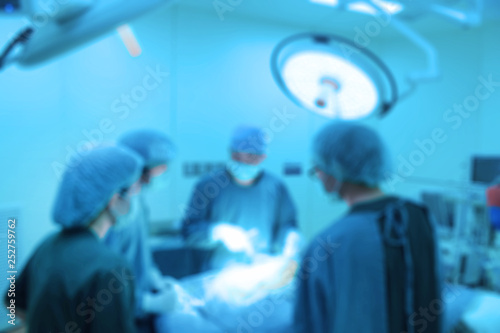 Blur of group of veterinarian surgery in operation room take with art lighting and blue filter