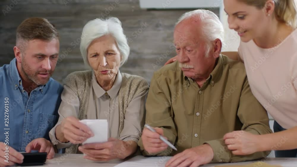 Tracking left of young woman bringing envelope with bills to other family members, and they starting counting budget together