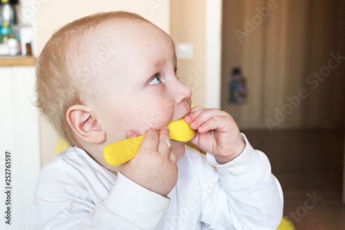 baby eat from blue plates with a yellow spoon