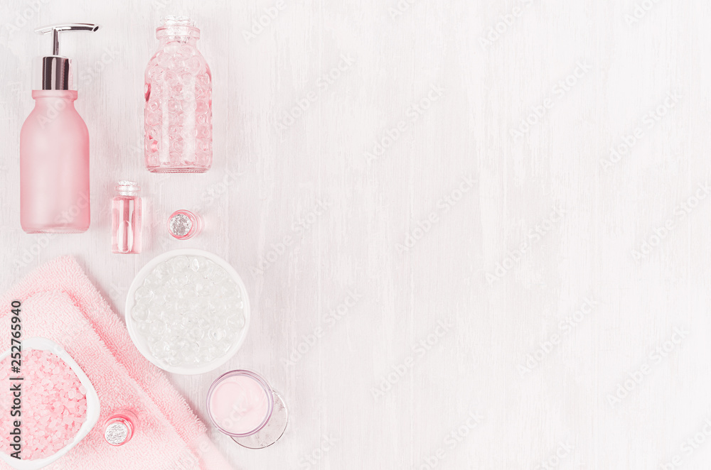 Elegance pink spa cosmetic products for skin and body care on soft white wood background, copy space, flat lay.