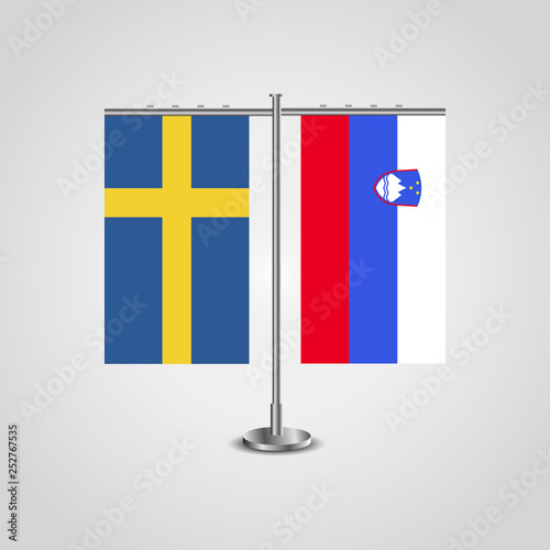 Table stand with flags of Sweden and Slovenia.Two flag. Flag pole. Symbolizing the cooperation between the two countries. Table flags