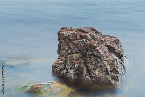 Stone in the water. Long exposure of water and rock. © J. Kearns
