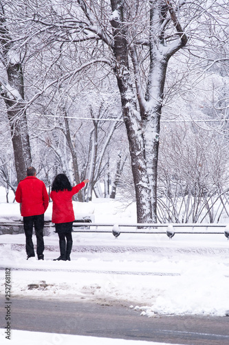 Man and woman in red jackets on a snowy street