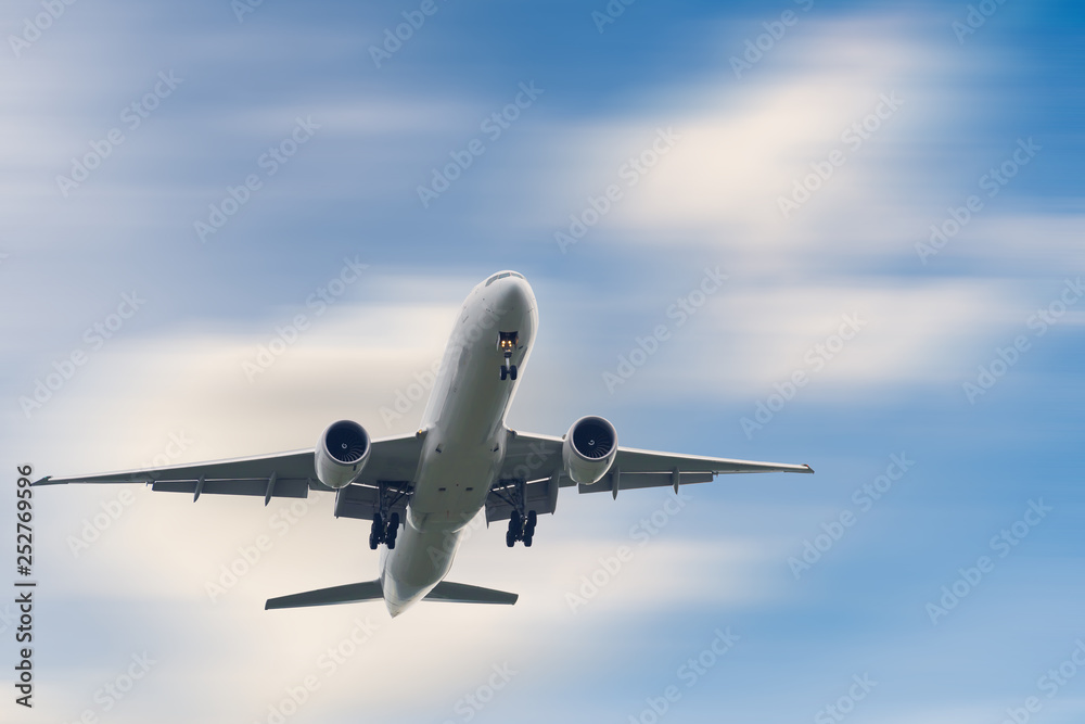 An Airplane is Flying in The Clouds Sky on Vacation Journey, International Aviation and Passengers Transportation, Holiday Trip and Traveling Tourist Concept.