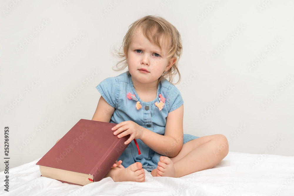 Cute little child in blue dress reading a book Cute little child in blue dress reading a book