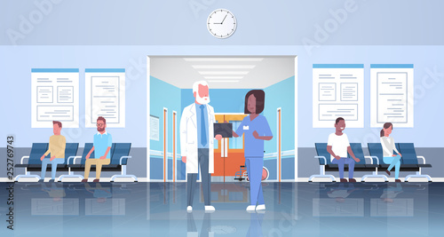 doctor and nurse discussing in hospital waiting hall corridor over mix race patients consultation and diagnosis healthcare concept modern clinic interior full length horizontal flat
