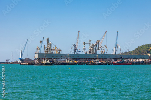 Seaport area, cranes loading ships in port, logistic import export business and transportation