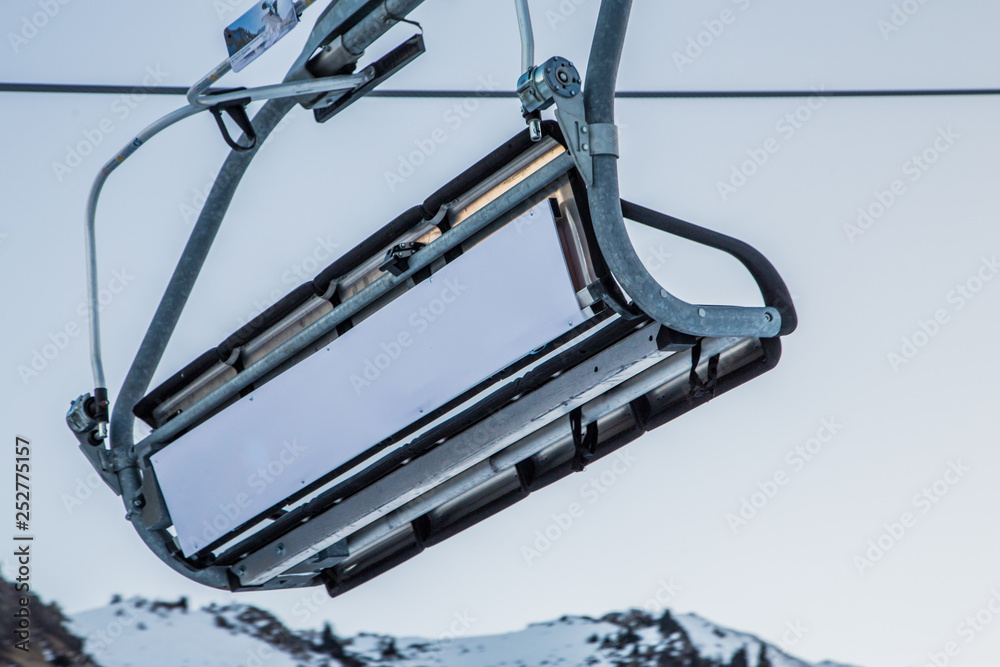 Empty ski lift with an empty white commercial banner in front of morning sky Empty ski lift with an empty white commercial banner in front of morning sky
