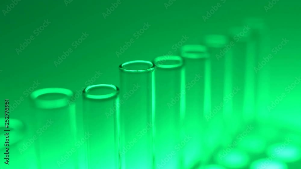 Glass test tubes in laboratory with green light. Close up 4K footage. Glass test tubes in laboratory with green light. Close up 4K footage.