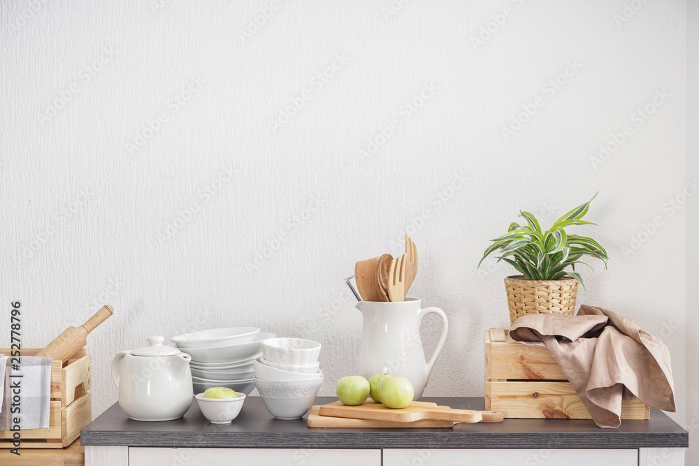 Kitchenware on table near white wall Kitchenware on table near white wall
