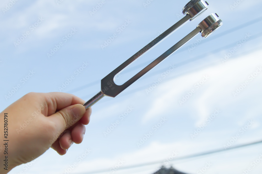 Obraz premium Hand holding a tuning fork .