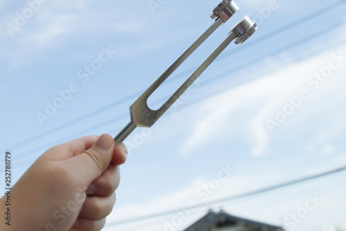 Hand holding a tuning fork .