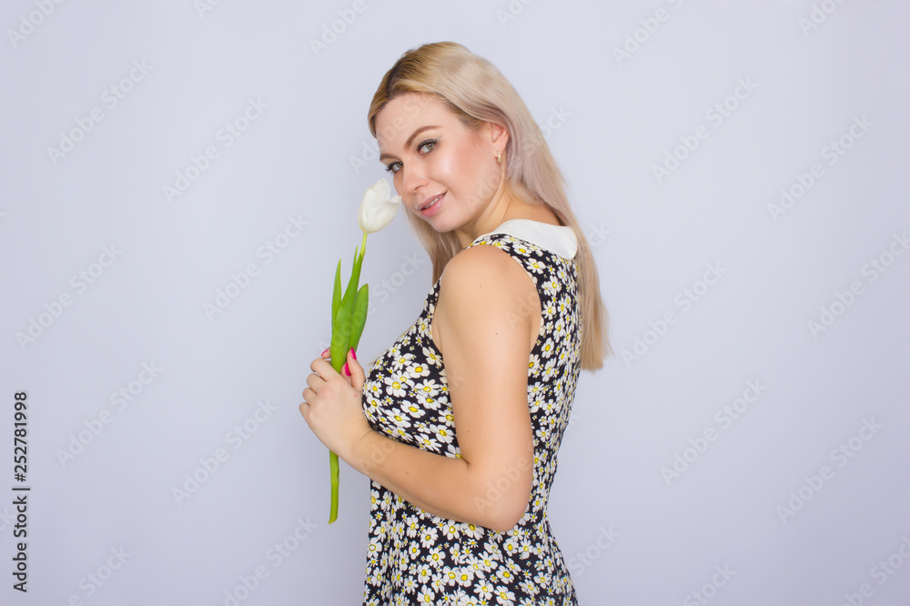 Blonde woman holding one white tulip Blonde woman holding one white tulip