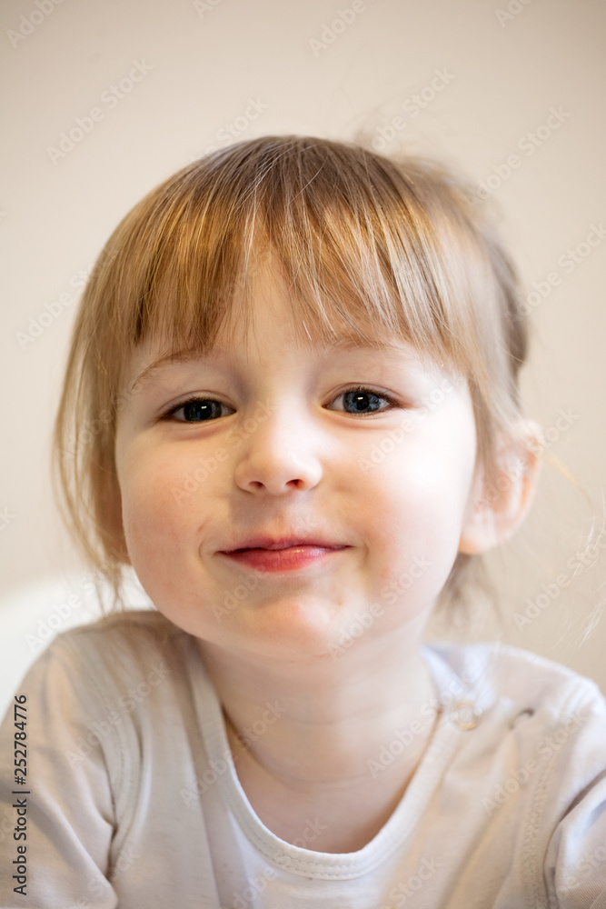 cute smiling child girl with blonde hair and quiff closeup portrait