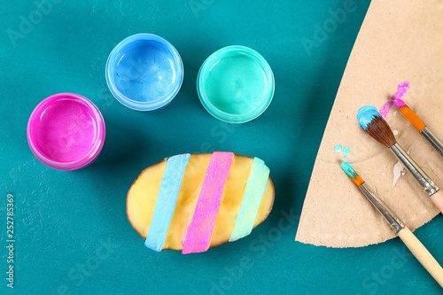 Diy Easter eggs made of cardboard and potato stamp, Easter greeting card on green background. photo