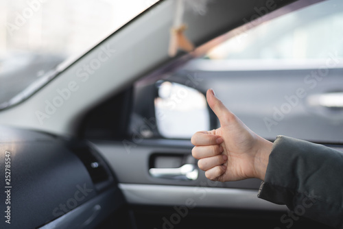 Car passenger is showing a thumbs up gesture and is satisfied by a driving of taxi driver.