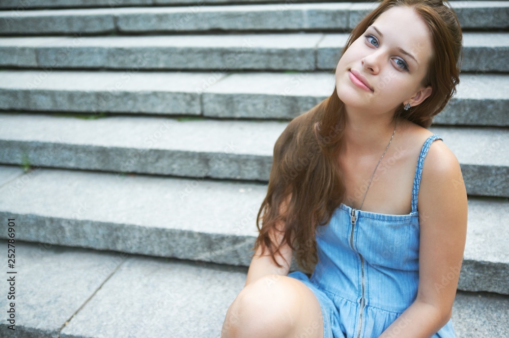 A young girl on the background of the stairs.