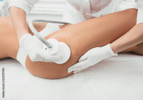 woman having cavitation, procedure removing cellulite on her buttocks , lifting buttocks