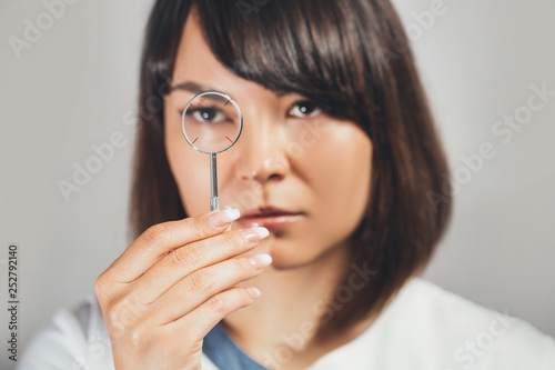 Doctor ophthalmologist holding lenses to check  patient's vision.  focus on  lens,  face is in soft focus. Concept - medical examination.