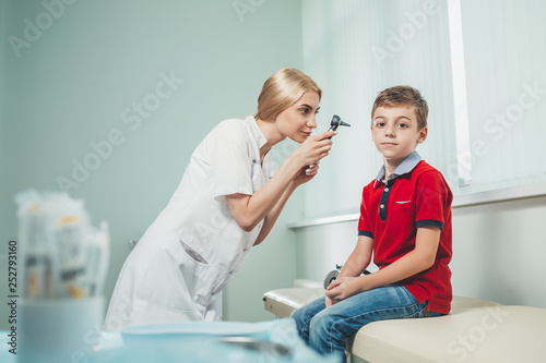 Children's ENT doctor examines boy's ear. Prevention of children's diseases. Copy space