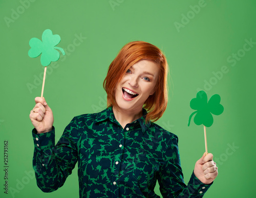 Portrait of screaming woman holding clover shaped banner