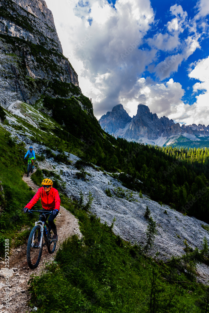 Mountain cycling couple with bikes on track, Cortina d'Ampezzo, Dolomites, Italy