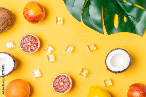 Fototapeta Naklejka Na Ścianę i Meble -  Tropical fruits, blood oranges, coconut, lemon, ice cubes, monstera leaf