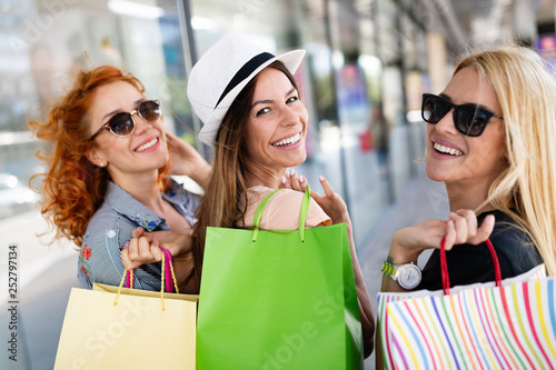 Happy women friends smiling and having fun while shopping together