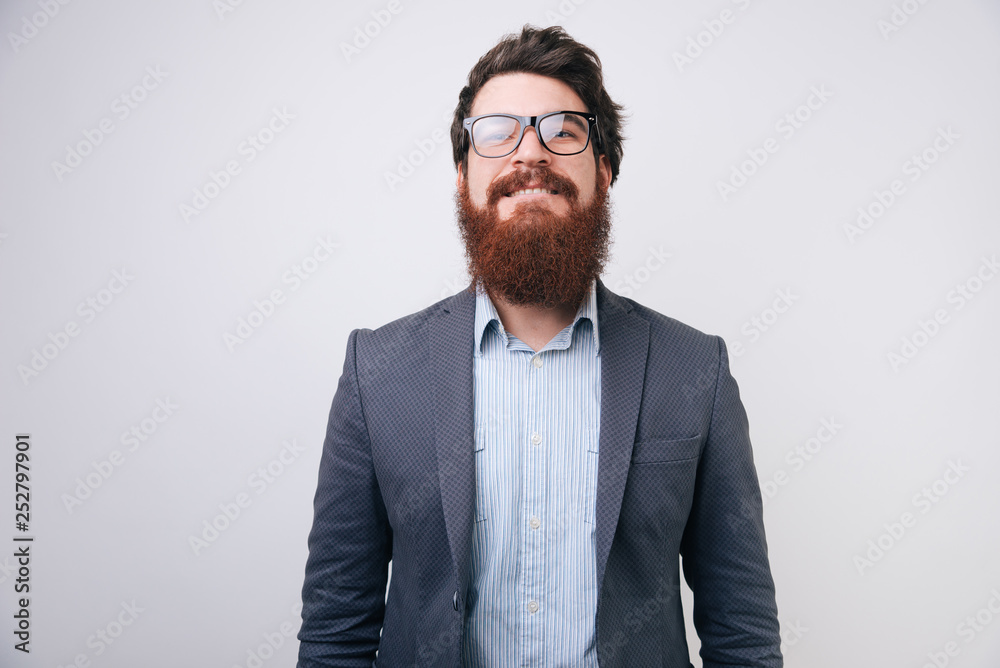 Bearded man wearing glasses looking at camera with a serious, happy expression in a close portrait Bearded man wearing glasses looking at camera with a serious, happy expression in a close portrait