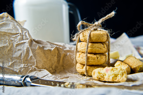 Homemade cookies, glass of milk. Black background, side view, close-up