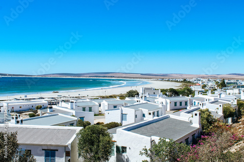 Scenic view of the picturesque town Paternoster with white houses and the turquoise ocean shoreline. © Anna