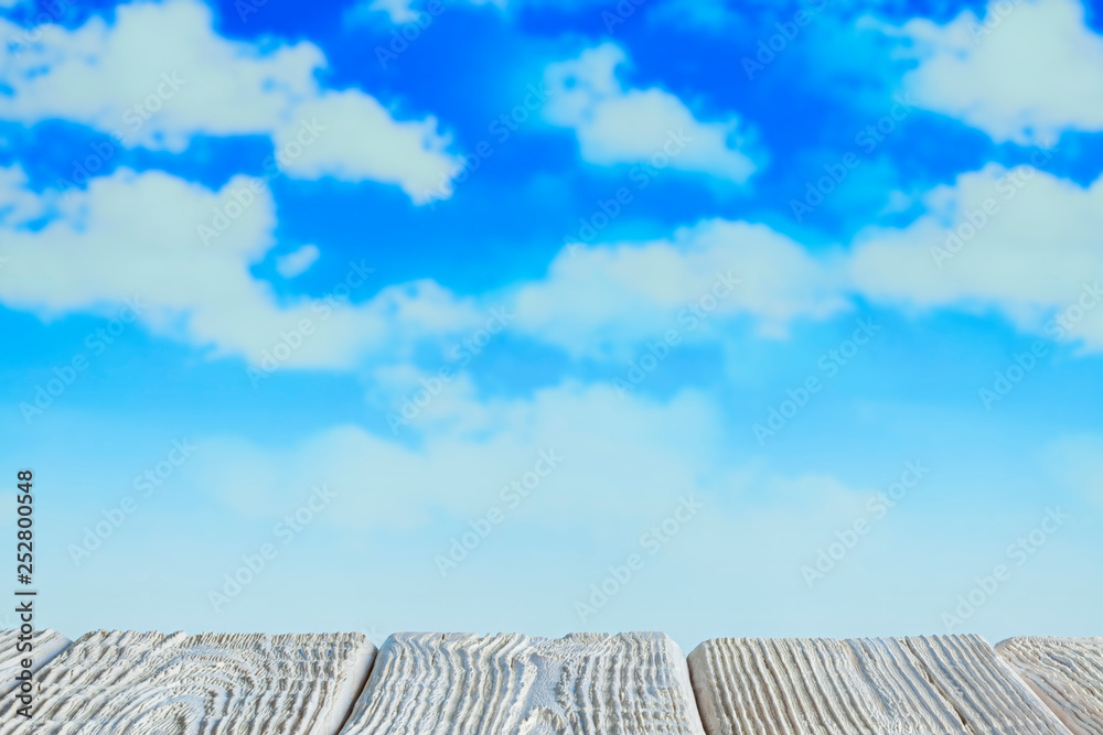 White wooden table with empty space on blue sky background