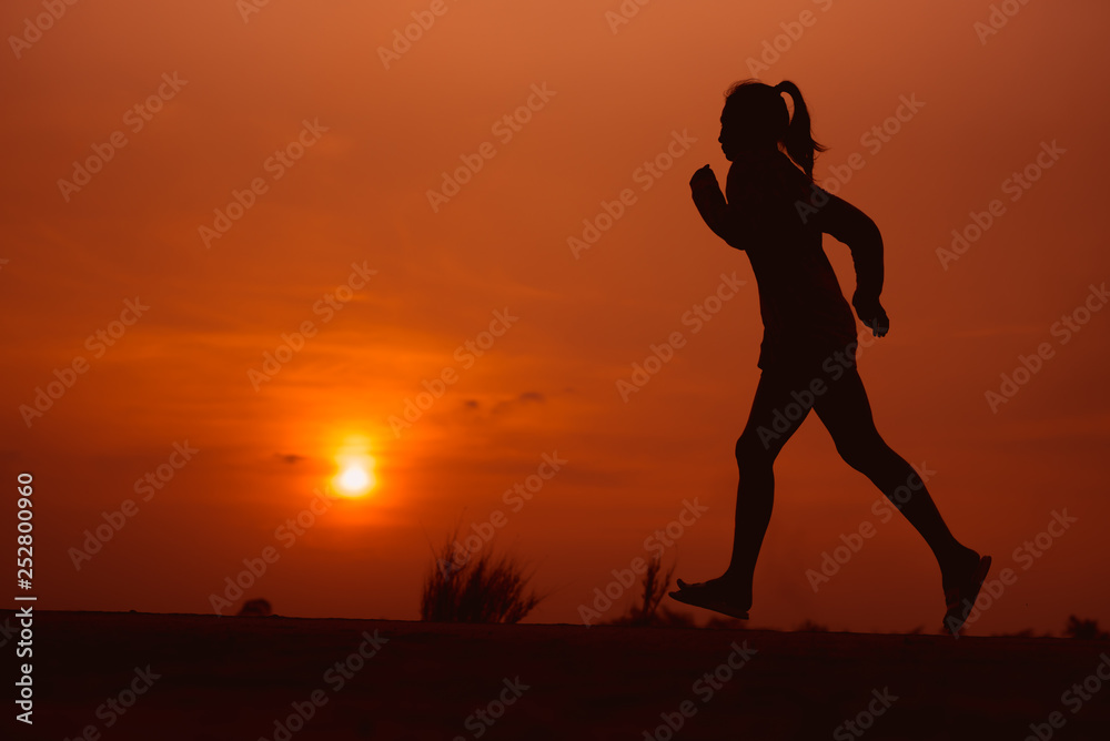 young fitness woman running on sunset seaside trail - Image