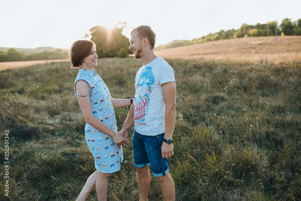 Fototapeta premium Young beautiful couple walking outside on beautiful sunset