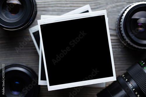Old black lenses and classic photo frames on wooden background