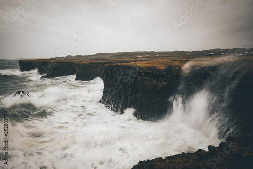 Gatklettur bay at the town of Arnarstapi in snaefellsnes penninsula Iceland during a storm with very high waves pumeling the cliffs 
