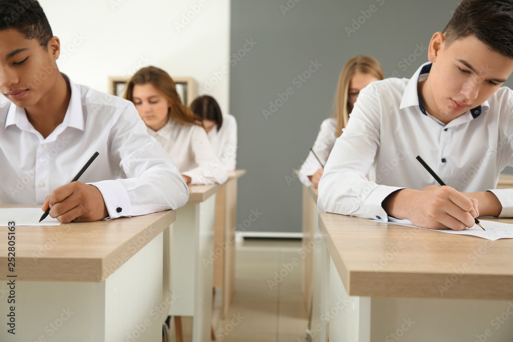 Pupils passing school test in classroom