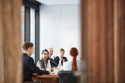View of business meeting in conference room through open door, copy space