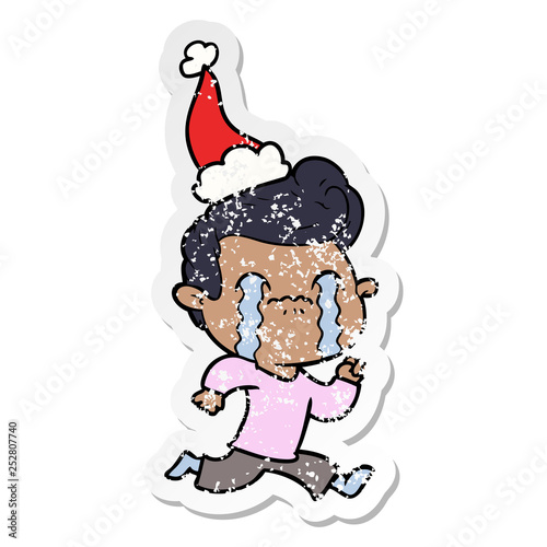 distressed sticker cartoon of a man crying wearing santa hat