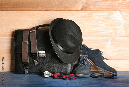 Set of male accessories on table against wooden background photo