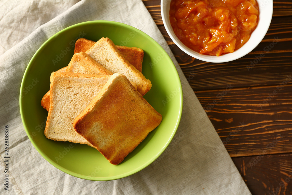 Bowl with tasty toasted bread and jam on wooden table Bowl with tasty toasted bread and jam on wooden table