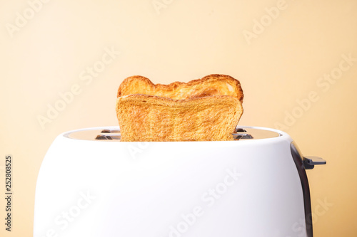 Slices of bread with toaster on color background