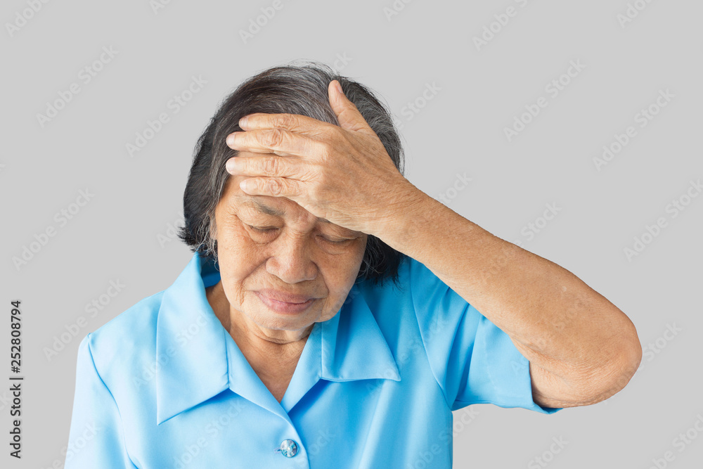 Stressed exhausted grandmother having strong tension headache on a gray background Stressed exhausted grandmother having strong tension headache on a gray background