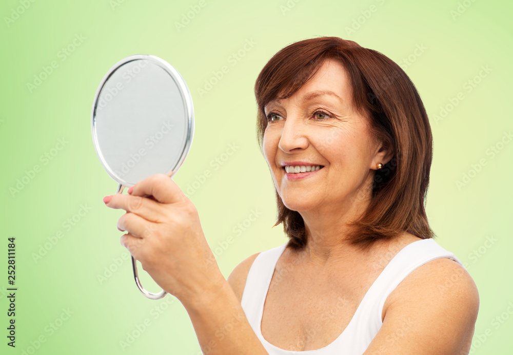 beauty and old people concept - portrait of smiling senior woman with mirror over lime green natural background beauty and old people concept - portrait of smiling senior woman with mirror over lime green natural background