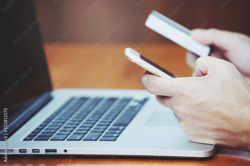Fototapeta premium close up people hands holding credit card and using phone and computer laptop. Online shopping purchase Sell or Payment.