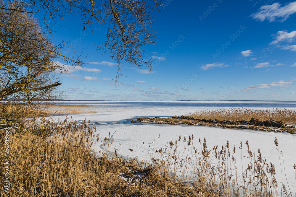 Winter landscape with frozen lake in clear weather