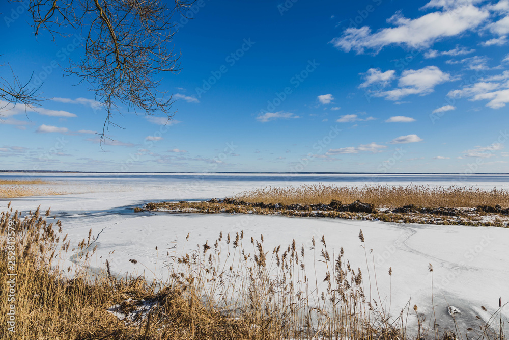 Winter landscape with frozen lake in clear weather