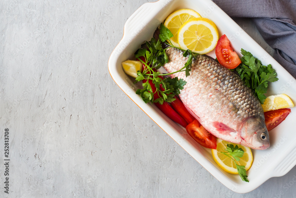 Raw carp fish with spices and vegetables for cooking. The view from the top. Copy space. Raw carp fish with spices and vegetables for cooking. The view from the top. Copy space.