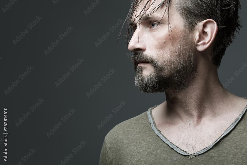 Fabulous at any age. Profile portrait of 40-year-old man with wet hair standing over dark gray background. Long hair on forehead. Rocker, biker style. Close up. Copy-space. Studio shot Stock Photo | Fabulous at any age. Profile portrait of 40-year-old man with wet hair standing over dark gray background. Long hair on forehead. Rocker, biker style. Close up. Copy-space. Studio shot Stock Photo |